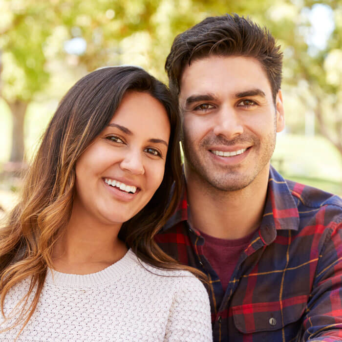 man and woman smiling outdoors