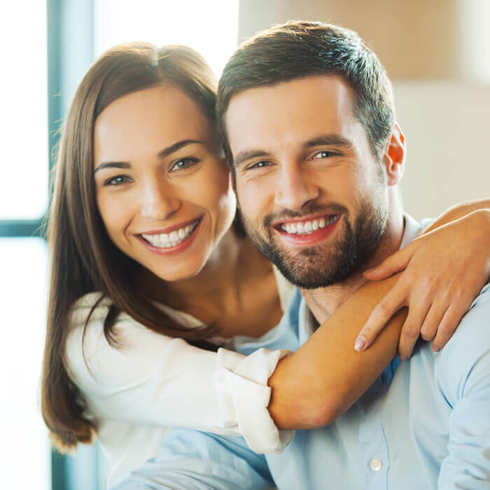man and woman smiling indoors