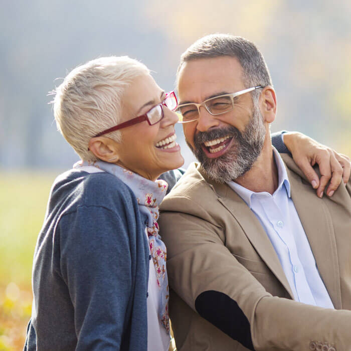 mature man and woman smiling outdoors